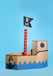 Photo of Pirate cardboard ship with flag on turquoise background