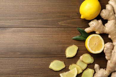 Photo of Fresh lemons and ginger on wooden table, flat lay. Space for text