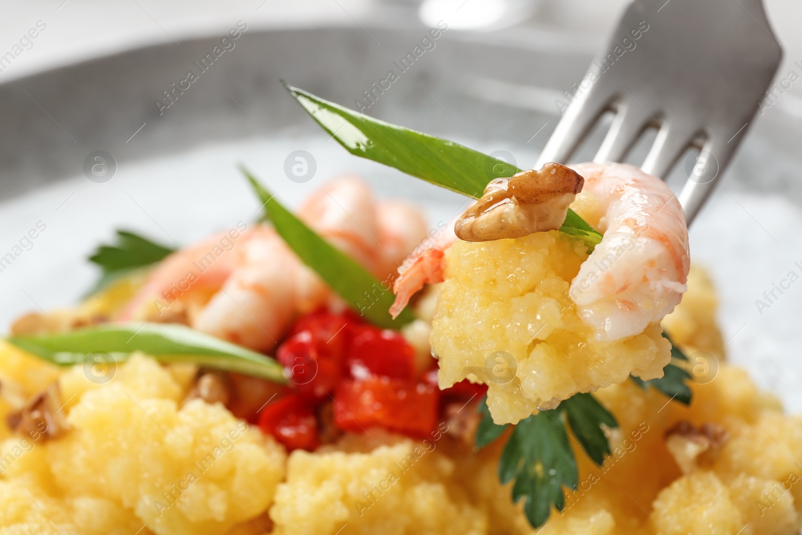 Photo of Fork with fresh tasty shrimp and grits, closeup