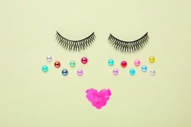 Photo of False eyelashes, beads and sequins as beautiful face on beige background, flat lay