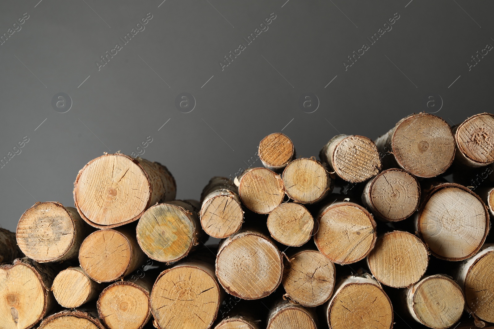 Photo of Cut firewood on grey background. Heating in winter