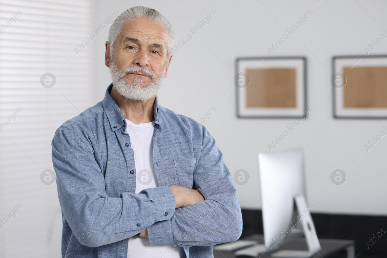 Photo of Portrait of handsome senior man in office. Space for text