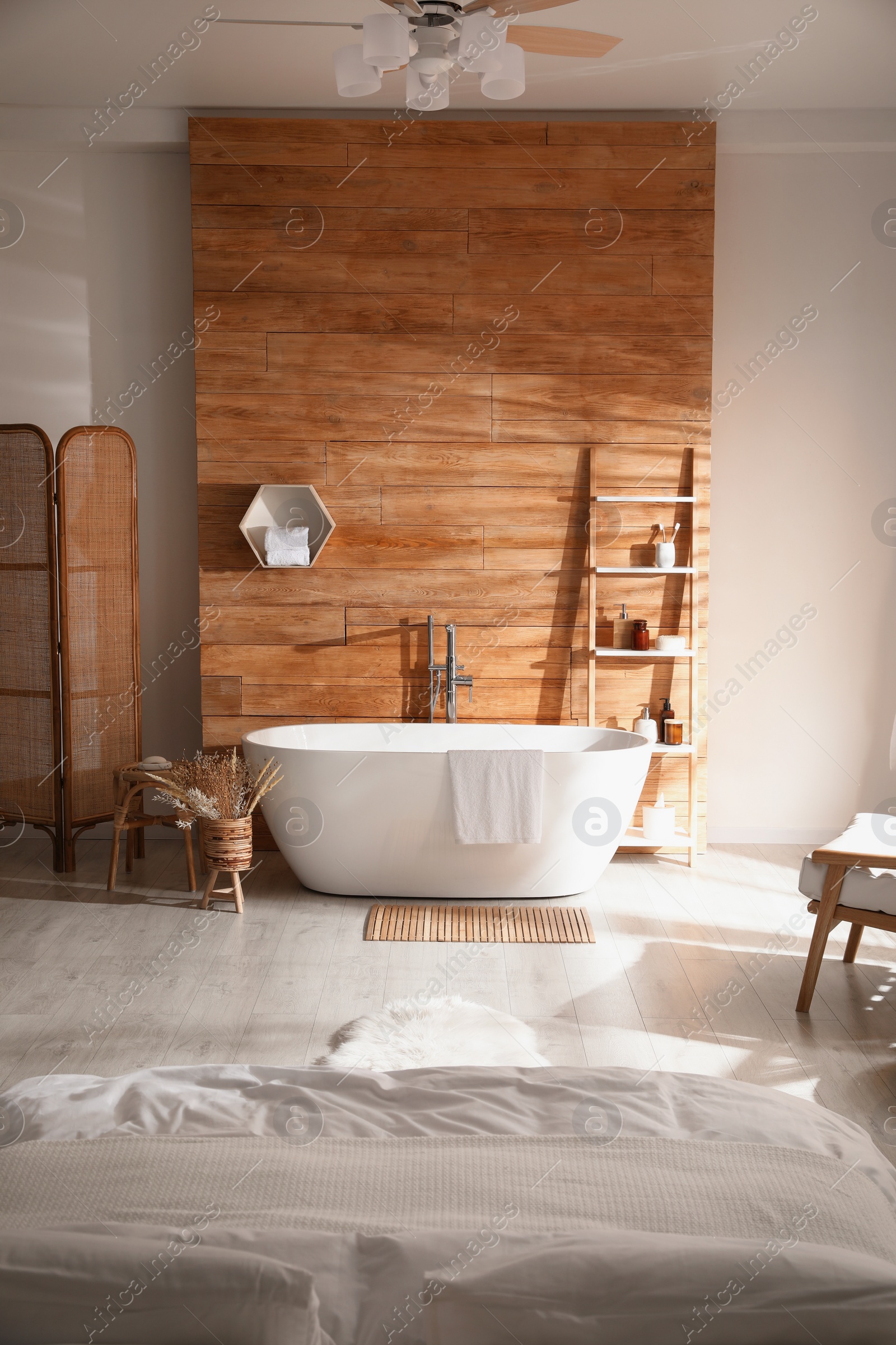 Photo of Stylish apartment interior with white bathtub and bed