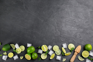 Photo of Lemonade layout with juicy lime slices, mint and ice cubes on black table, top view. Space for text. Space for text