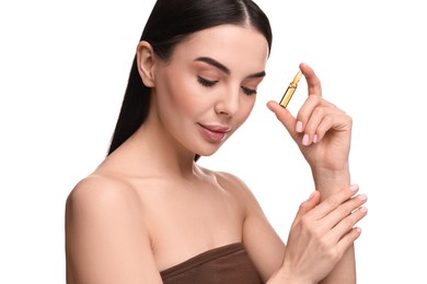 Beautiful young woman holding skincare ampoule on white background