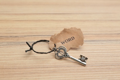 Photo of Vintage key with tag on wooden table. Keyword concept
