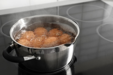Photo of Cooking chicken eggs in pot on electric stove. Space for text