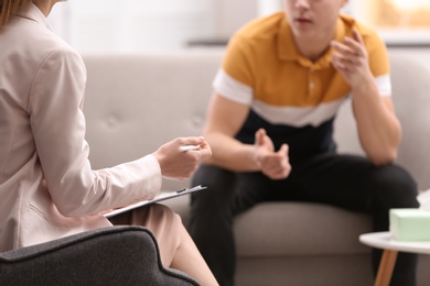 Psychotherapist working with young man in office, closeup