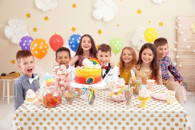 Cute children celebrating birthday at table indoors