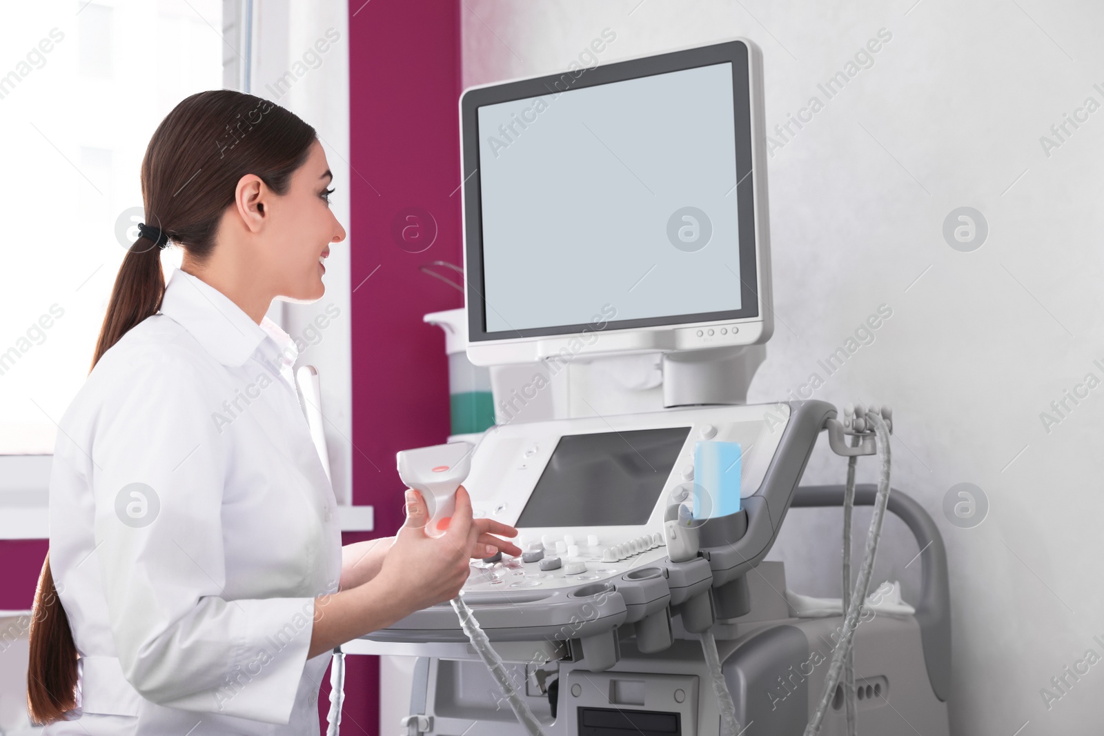 Photo of Sonographer using modern ultrasound machine in clinic