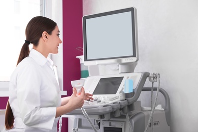 Photo of Sonographer using modern ultrasound machine in clinic