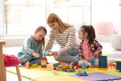 Photo of Mother playing with her children at home