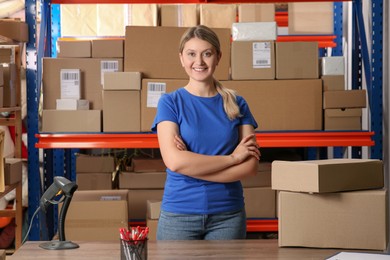 Post office worker near rack with parcels indoors