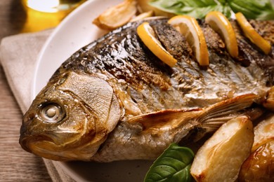 Tasty homemade roasted crucian carp served on table, closeup. River fish