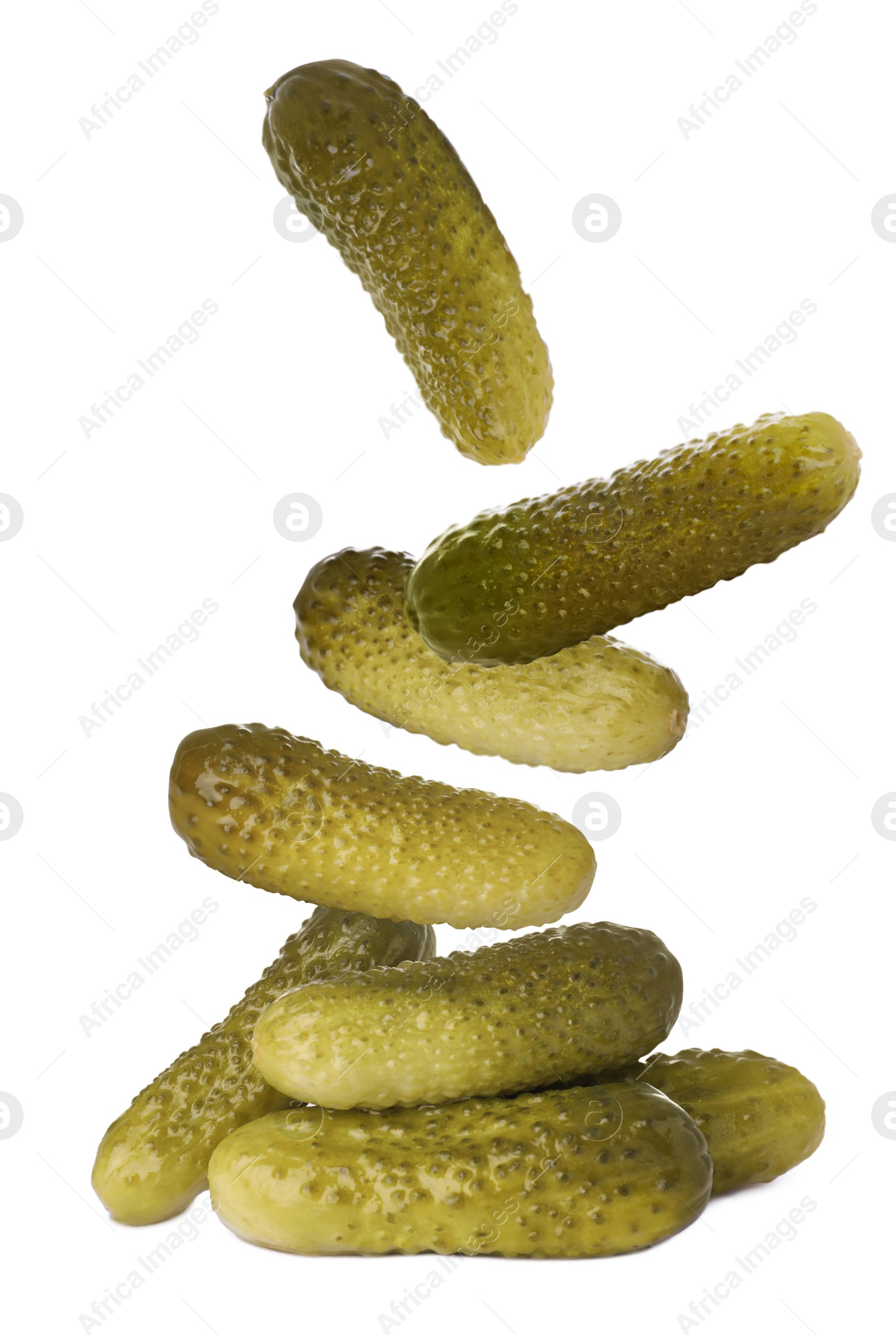 Image of Tasty pickled cucumbers falling into pile on white background