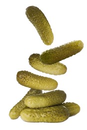 Tasty pickled cucumbers falling into pile on white background