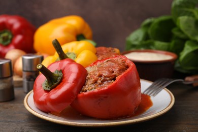 Photo of Delicious stuffed bell peppers served on wooden table