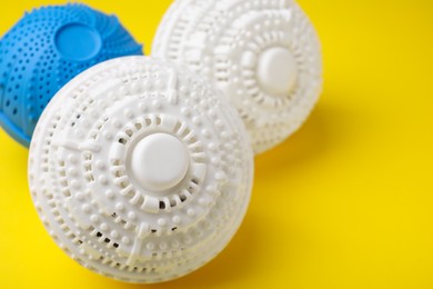 Laundry dryer balls on yellow background, closeup. Space for text