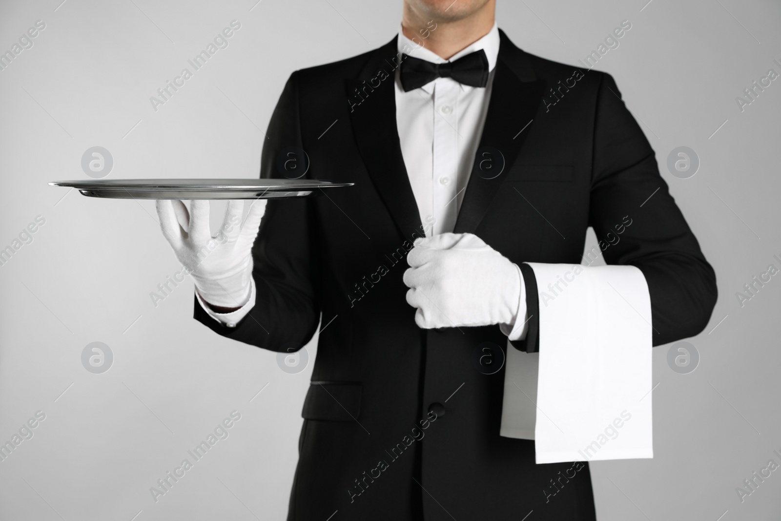 Photo of Butler with tray on light grey background, closeup