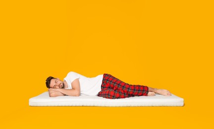 Photo of Man sleeping on soft mattress against orange background