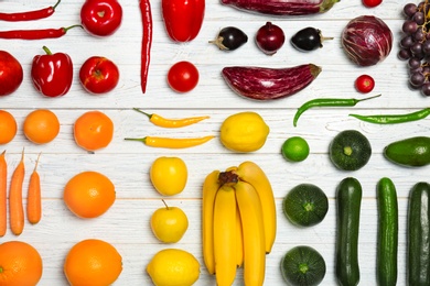 Photo of Rainbow composition with fresh vegetables and fruits on wooden background, flat lay