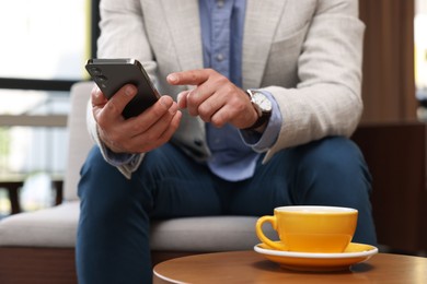 Photo of Man using his smartphone in cafe, closeup
