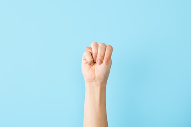 Photo of Woman showing M letter on color background, closeup. Sign language