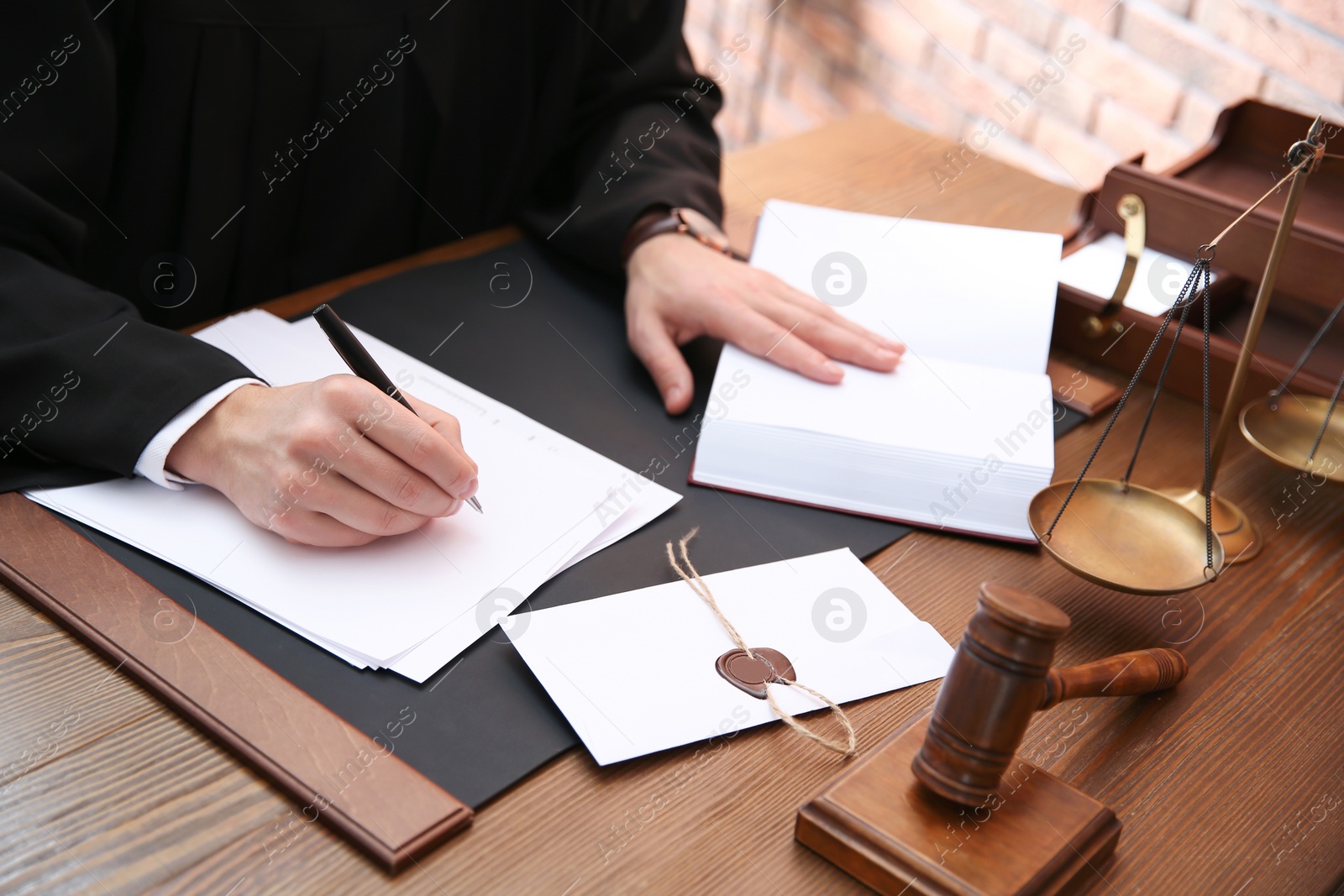 Photo of Judge working with papers at table in office, closeup. Law and justice concept
