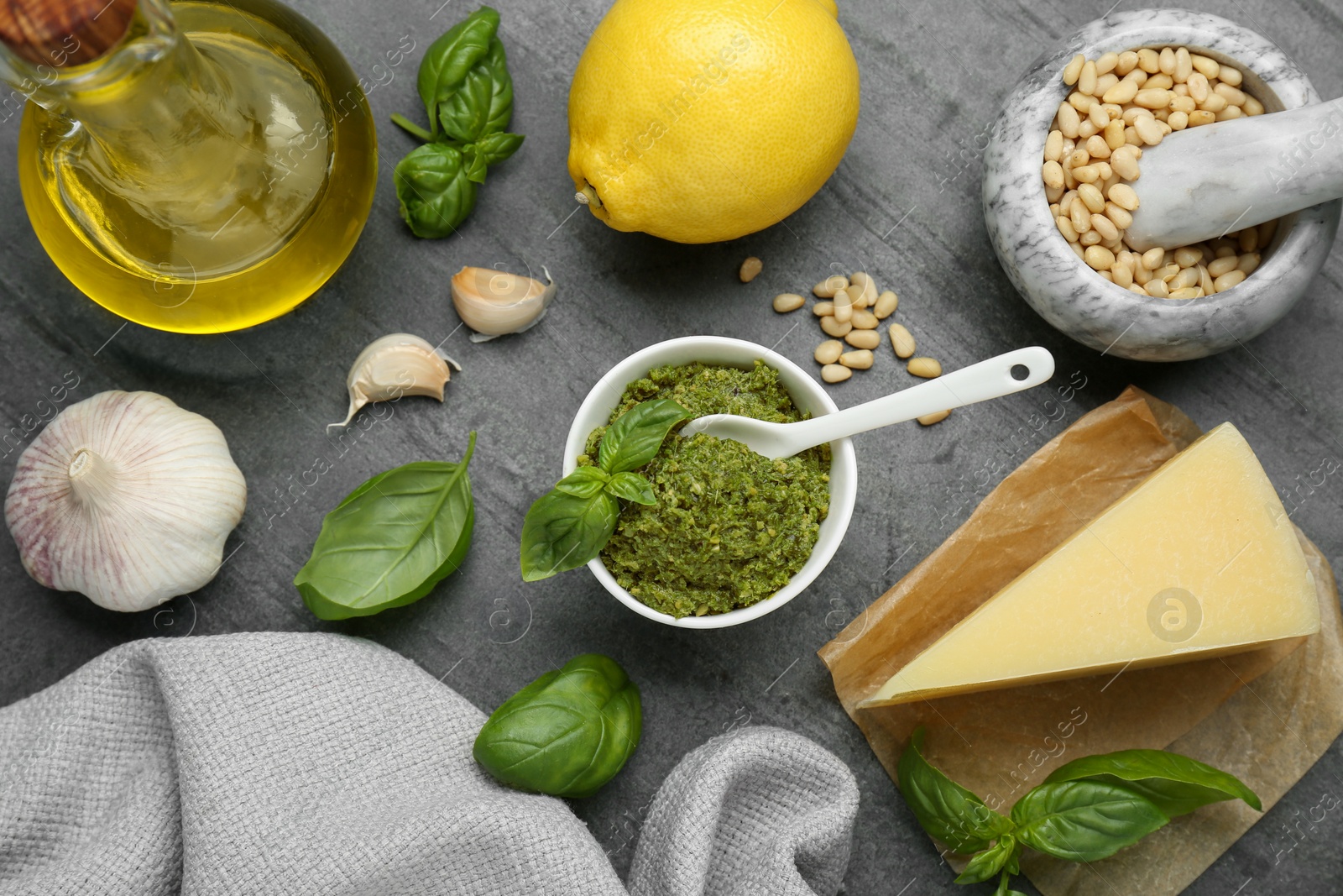 Photo of Delicious pesto sauce and ingredients on grey table, flat lay