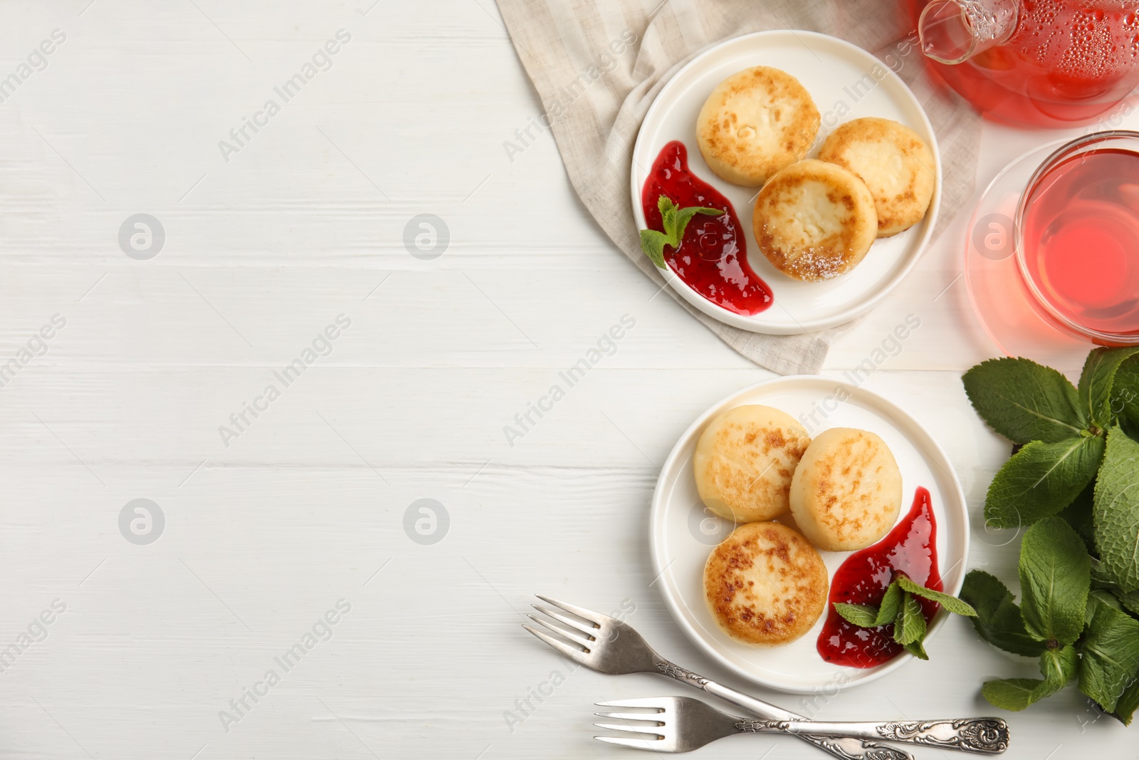 Photo of Delicious cottage cheese pancakes with jam and mint on white wooden table, flat lay. Space for text
