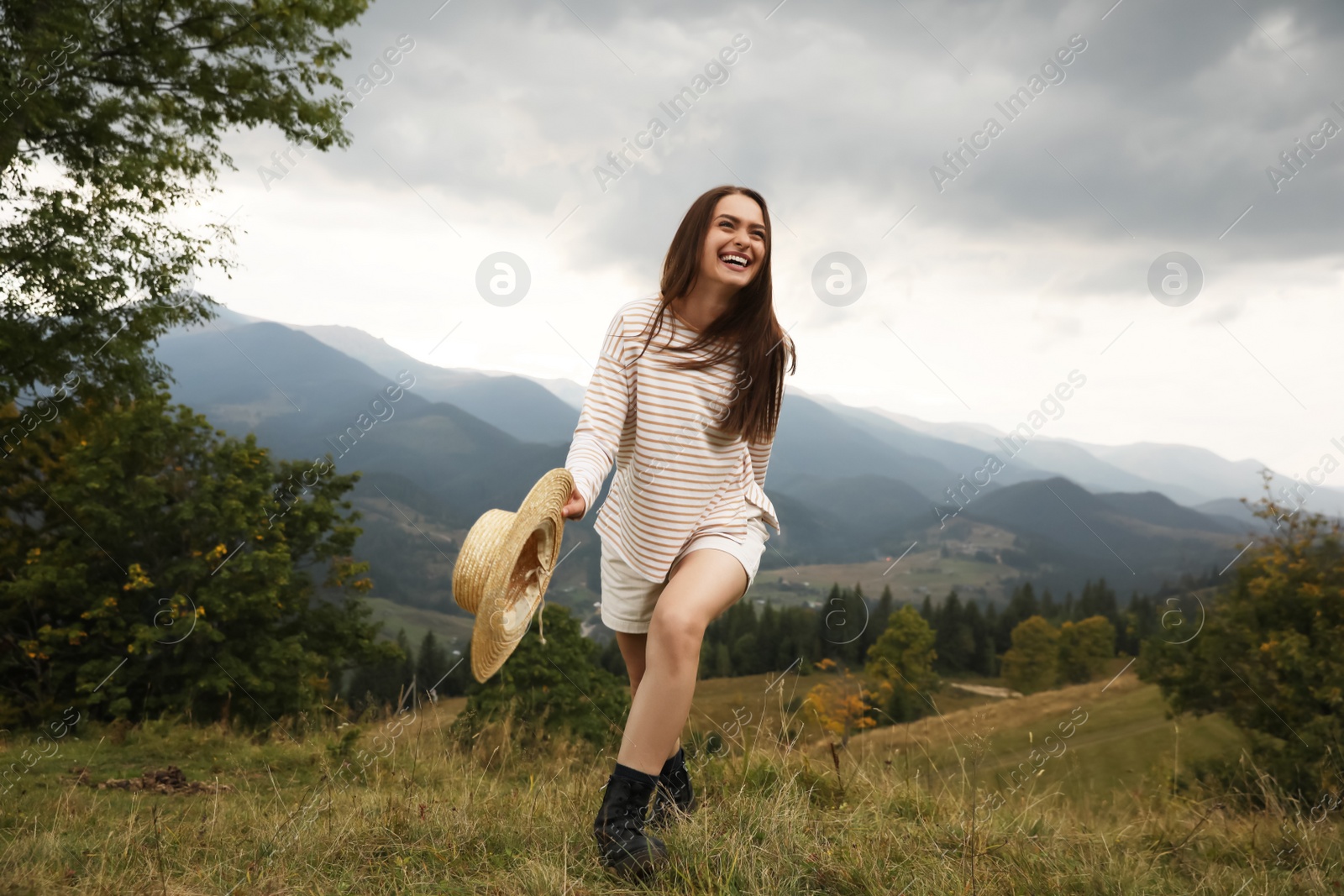 Photo of Young woman with stylish hat enjoying her time in mountains