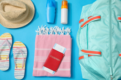 Flat lay composition with bag and travel accessories on blue background