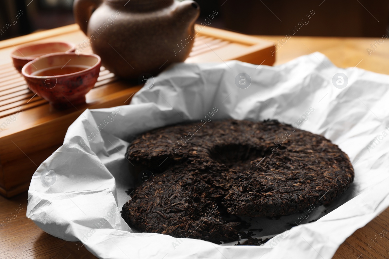 Photo of Broken disc shaped pu-erh tea on wooden table