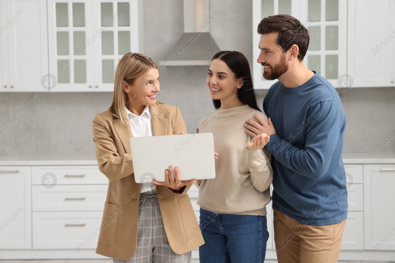 Photo of Real estate agent working with couple in new apartment