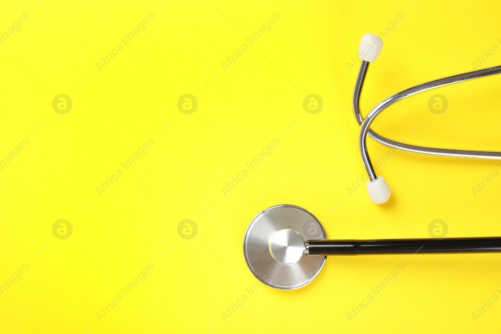 Photo of Stethoscope with space for text on color background, top view. Medical tool