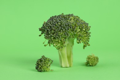 Fresh raw broccoli on light green background