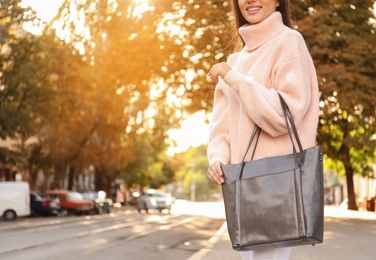 Photo of Woman with stylish shopper bag outdoors, closeup. Space for text