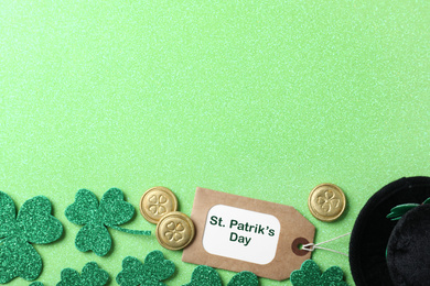 Clover leaves and tag with phrase St. Patrick's Day on light green background, flat lay. Space for text