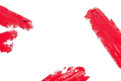 Photo of Red lipstick smears on white background, top view. Space for text