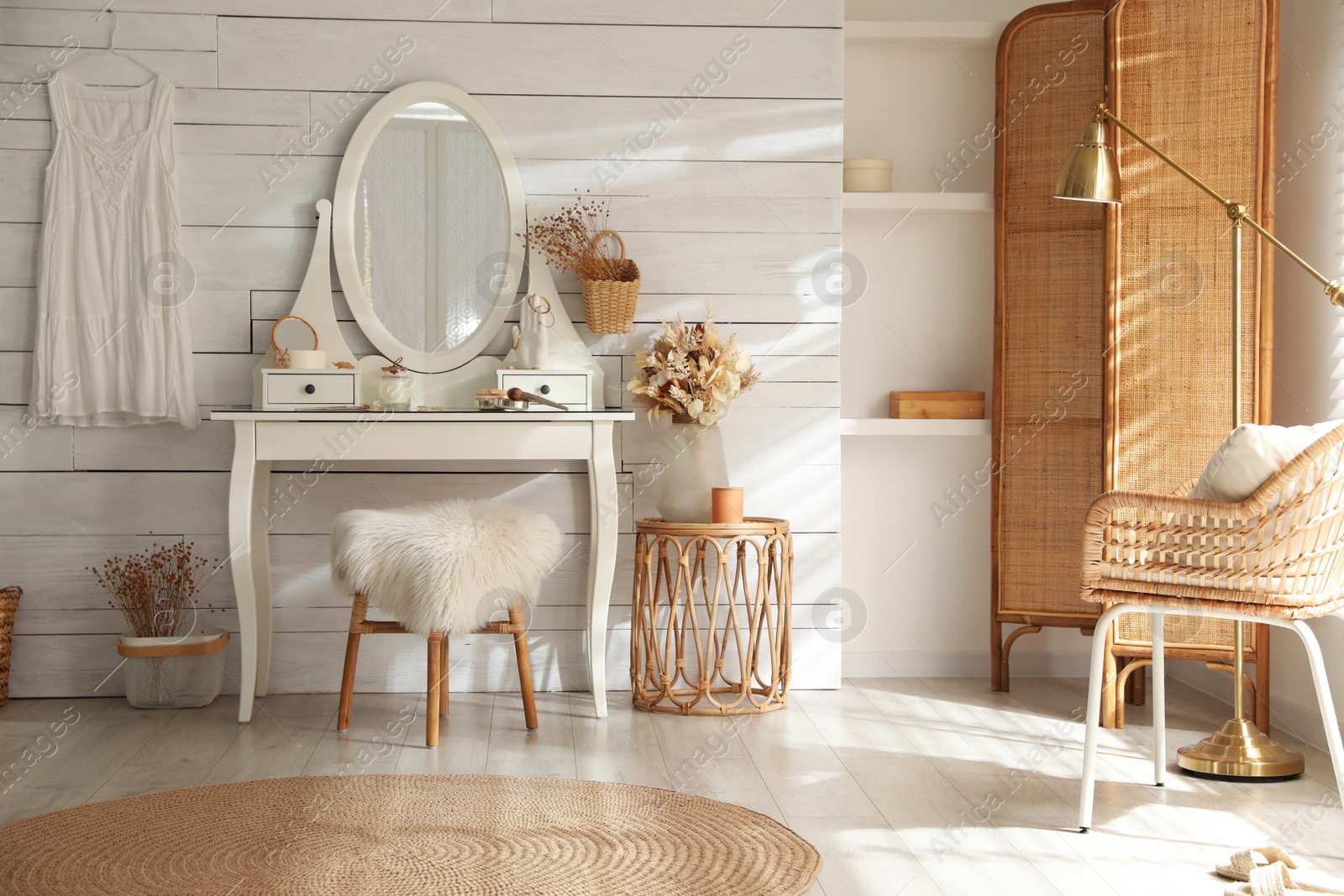 Photo of Wooden dressing table with decorative elements and makeup products in room. Interior design