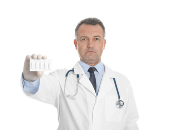 Photo of Doctor holding suppositories for hemorrhoid treatment on white background