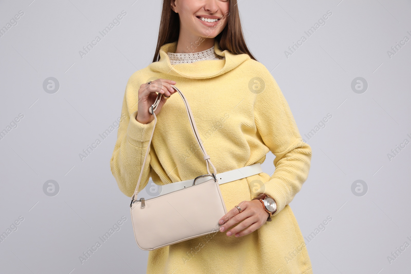 Photo of Fashionable young woman with stylish bag on light background, closeup