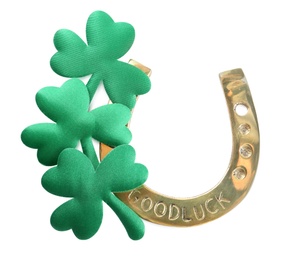 Golden horseshoe and decorative clover leaves on white background, top view. Saint Patrick's Day celebration