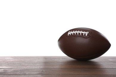 Photo of American football ball on wooden table against white background. Space for text