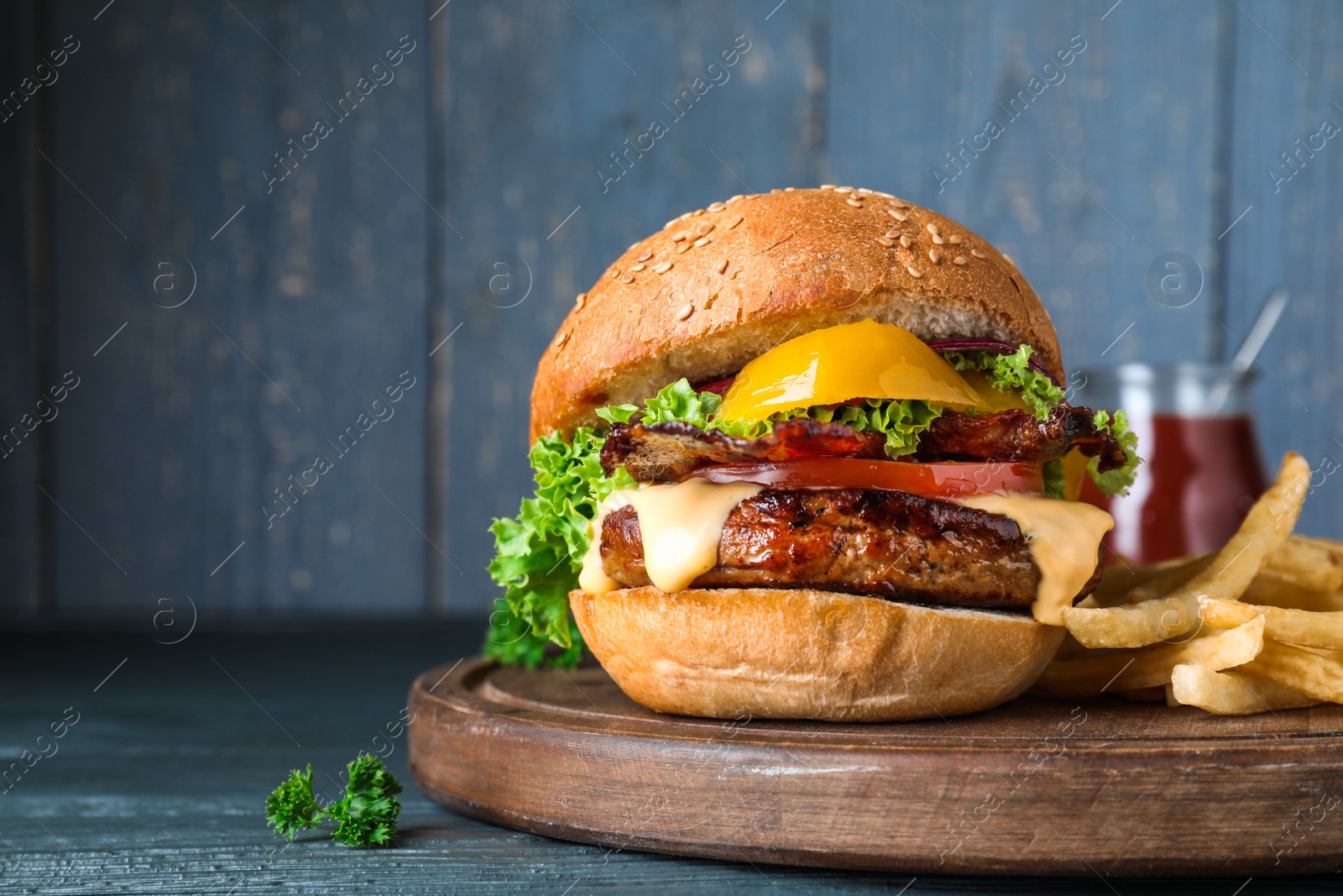 Photo of Fresh juicy bacon burger on grey table. Space for text