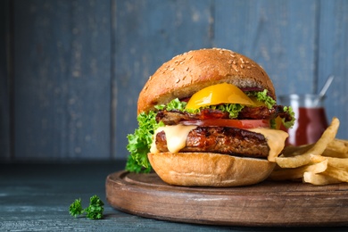 Photo of Fresh juicy bacon burger on grey table. Space for text