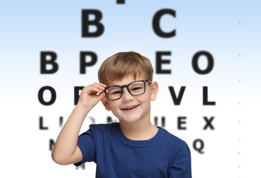 Vision test. Little boy in glasses and eye chart on gradient background