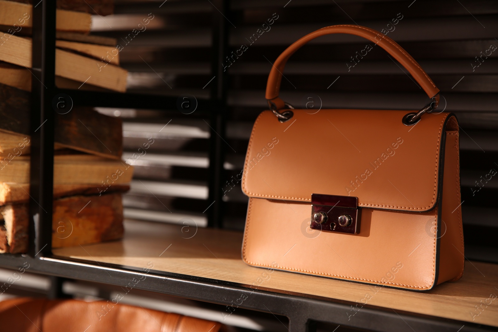 Photo of Stylish woman's bag on shelf in boutique