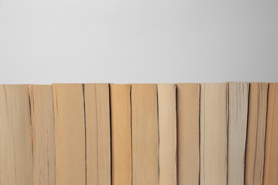 Photo of Collection of different books on light background, space for text