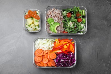 Set of glass containers with fresh food on grey table, flat lay